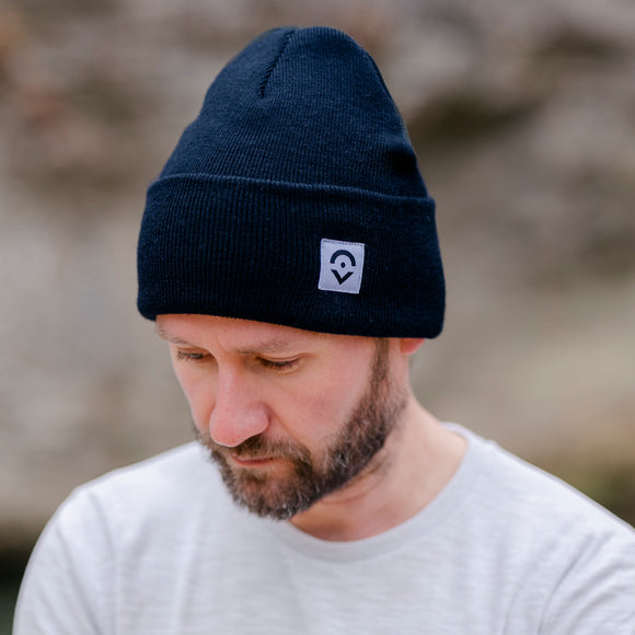 Outsider Navy Blue Rib Knit Beanie modeled by a man in nature