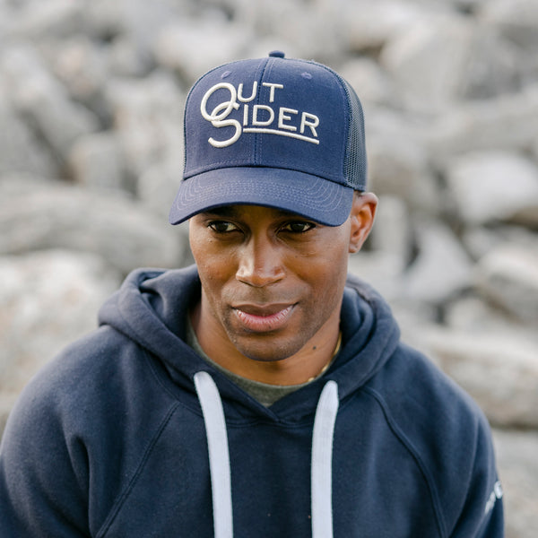 Navy Blue front panel and hat brim with White Outsider logo modeled on a man