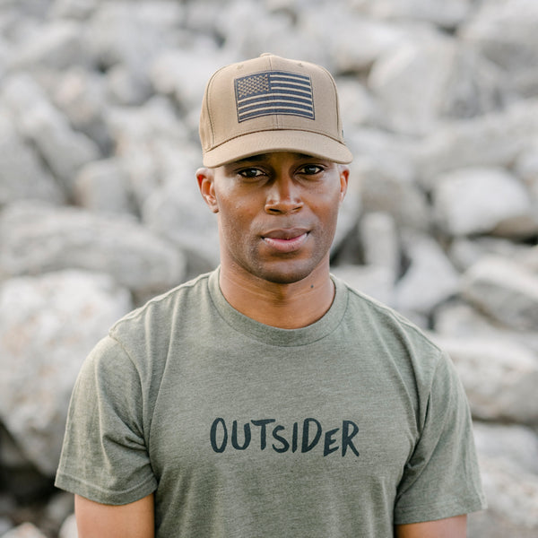 Desert Sand Tan Hat with blacked out black and tan American flag on the front modeled on man